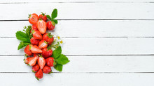 Strawberry With Leaves On A White Wooden Background. Berries Top View. Free Space For Your Text.