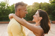 © Drobot Dean - Portrait of cheerful middle-aged couple looking at each other and hugging while walking in summer park