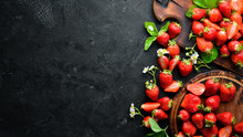 Fresh Strawberry With Leaves On A Black Stone Background. Berries Top View. Free Space For Your Text.