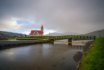 Wall Mural - Church and the river Stora located in Sandavagur on Faroe Islands, Denmark