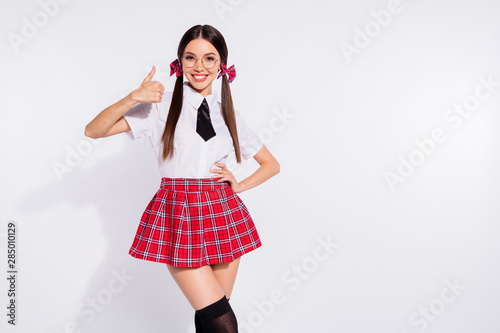 Fototapeta na szkło Portrait of her she nice-looking attractive lovely charming cute cheerful cheery positive confident girl wearing checkered skirt showing thumbup choose choice isolated over light white background