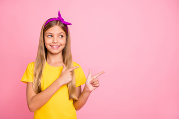 Poster - Photo of positive cheerful friendly cute schoolkid showing direction somewhere while isolated with pink background