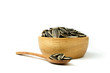 Close up of sunflower seeds isolated in wooden bowl against and spoon on white background and clipping path.