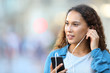 © Antonioguillem - Mixed race woman putting earphones listening to music