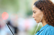 © Antonioguillem - Mixed race woman e-learning using tablet and earphones