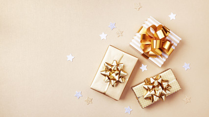 gift or present boxes and stars confetti on golden table top view. flat lay composition for birthday