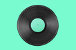 Vinyl record on a colored background. Old vintage vinyl record isolated on turquoise  background