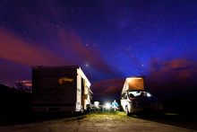 Campervans Are Parked On A Beach At Night Under Stars.