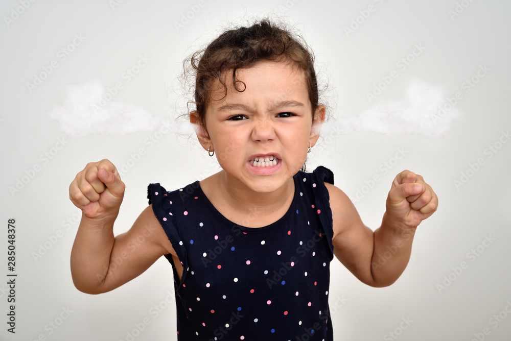 Angry and aggressive young girl with clenched teeth and fists and steam blowing out of her ears looking at the camera - obrazy, fototapety, plakaty 