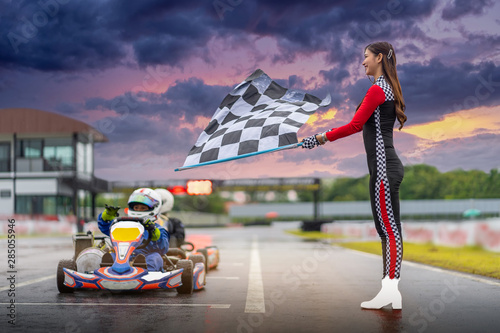 Fototapety Karting  kobieta-trzyma-rozpoczynajaca-gokart-car-racing-flage-na-zewnatrz