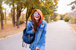 © ClaudiK - Outdoor fashion portrait of stylish young woman having fun, emotional face , laughing, looking at camera. Urban city street style. Long jeans coat and orange hoodie. Spring or fall outfit.