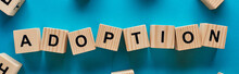Top View Of Adoption Word Made Of Wooden Cubes On Blue Background, Panoramic Shot