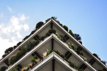 View on a house from the downside. Geometry of balconies. Blue sky on the background