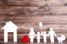 Family And House Figures With Red Padlock Heart On Wooden Table