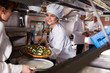 © JackF - Female chef giving cooked pizza to waitress