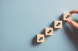 © oatawa - Business concept growth success process, Close up Woman hand arranging wood block stacking as step stair on paper blue background, copy space.