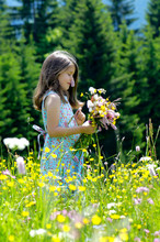 Girl With Bunch Of Flowers In Summer Meadow