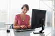 © Westend61 - Woman working on computer, wearing headset