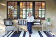 © Trinette Reed/Stocksy - Portrait of beautiful and stylish mature woman interior designer with grey hair sitting on front porch