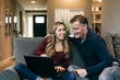 © Sean Locke Photography/Stocksy - Home: Father And Daughter Laugh While Using Laptop