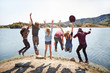 © Trinette Reed/Stocksy - Group of friends jumping in the air at lake
