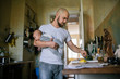 © VegterFoto/Stocksy - Father cooking and carrying his baby