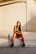 © Javier D?ez/Stocksy - Beautiful sportswoman sitting on pavement