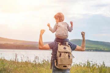 Father's day. Happy family: father and son travel together as tourists carry backpacks, go camping, relax, travel. Father and son have fun and play in nature