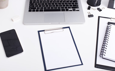 Black and white stylish workplace with clipper and laptop