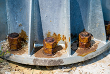 Steel Bolts And Rusty Steel Nut On Gray Steel Plate Of Lamp Post. Structural Detail Of A Lighting Post Base