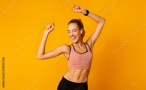 Fotomural Excited Young Lady In Sportswear Dancing On Yellow Background