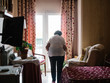 © Patricia Becaroto/ADDICTIVE STOCK - Back view of unrecognizable elderly woman walking to window in bedroom
