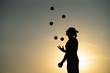 Silhouette of a man Juggling with Balls at Sunset