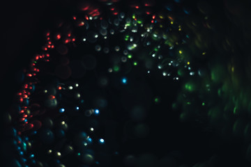 Poster - Beautiful multi colored light bokeh on a black background.