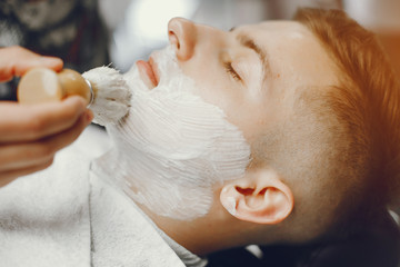 Wall Mural - A man in a barbershop. Clipping beard in the barber. Rest in hairdressing salon