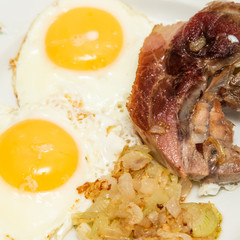 Fried eggs and a piece of meat, breakfast food.