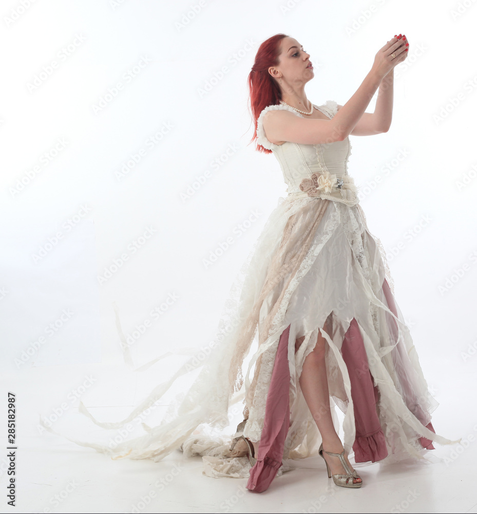 full length portrait of red haired girl wearing torn and tattered wedding  dress. Standing pose against a white studio background. Stock Photo | Adobe  Stock