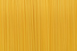 Dry uncooked spaghetti pasta as a background.