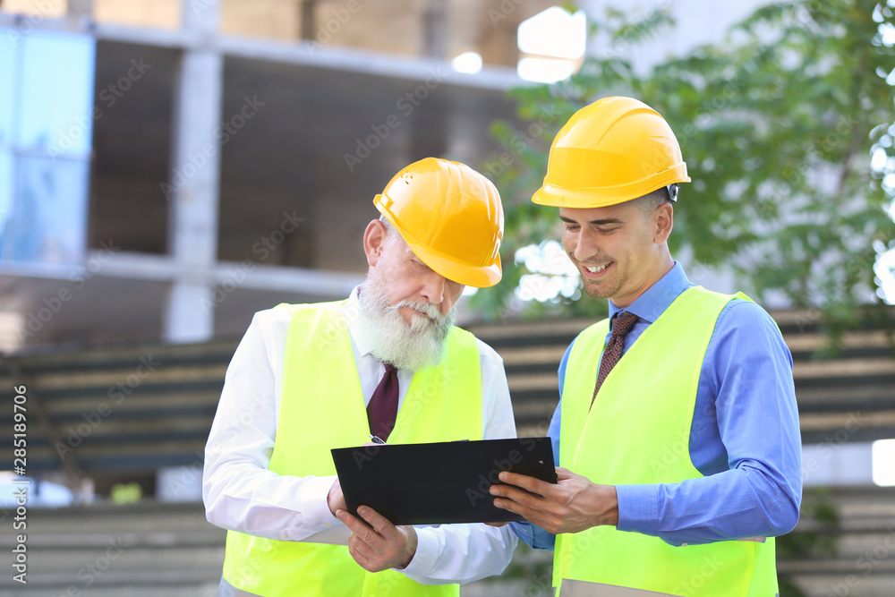 Architects discussing project of building outdoors