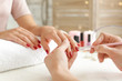 Woman getting professional manicure in beauty salon, closeup