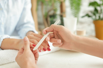 Woman getting professional manicure in beauty salon, closeup