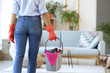 © Pixel-Shot - Woman with cleaning supplies in room, back view