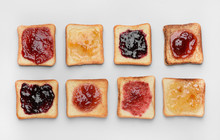 Tasty Toasted Bread With Different Jams On White Background