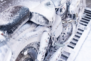 Wall Mural - Close up of motorcycle at the car wash with foam.