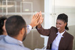 © Mangostar - Happy business partners celebrating closing deal. Multiethnic group of man and women sitting outside, joining hands and giving high five to each other. Partnership concept