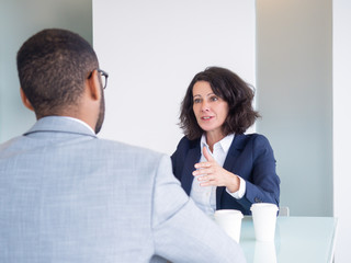 Personnel manager and job applicant meeting for interview. Business man and woman sitting at meeting table and talking. Career concept