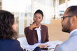 © Mangostar - Multiethnic business partners discussing contract terms in outdoor cafe. African American business woman sitting at table and listening to her colleague. Partner meeting concept