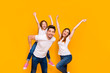 © deagreez - Portrait of three nice attractive charming cute lovely stylish cheerful cheery childish playful glad ecstatic person having fun dancing isolated over bright vivid shine yellow background