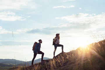 young tourist couple travellers with backpacks hiking in nature.