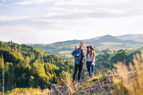 Young tourist couple travellers with backpacks hiking in nature, resting Poster Mural XXL